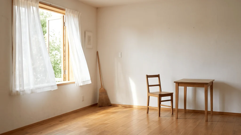 A clean house living room with open windows and clear floors, showing how a clean space lets air move and the mind settle